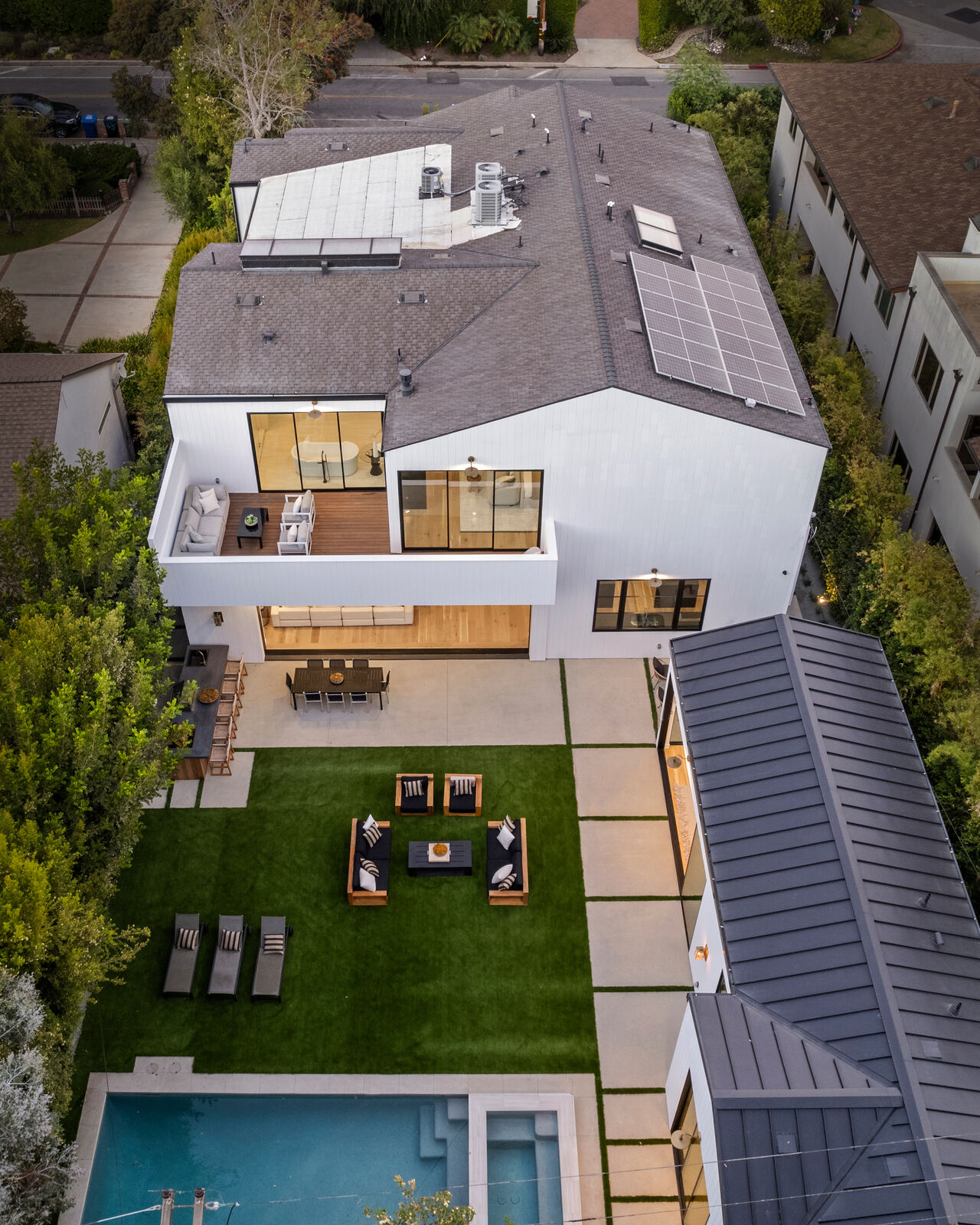 Aerial view of a modern San Fernando Valley home with patio and lawn by Totally Green Builders