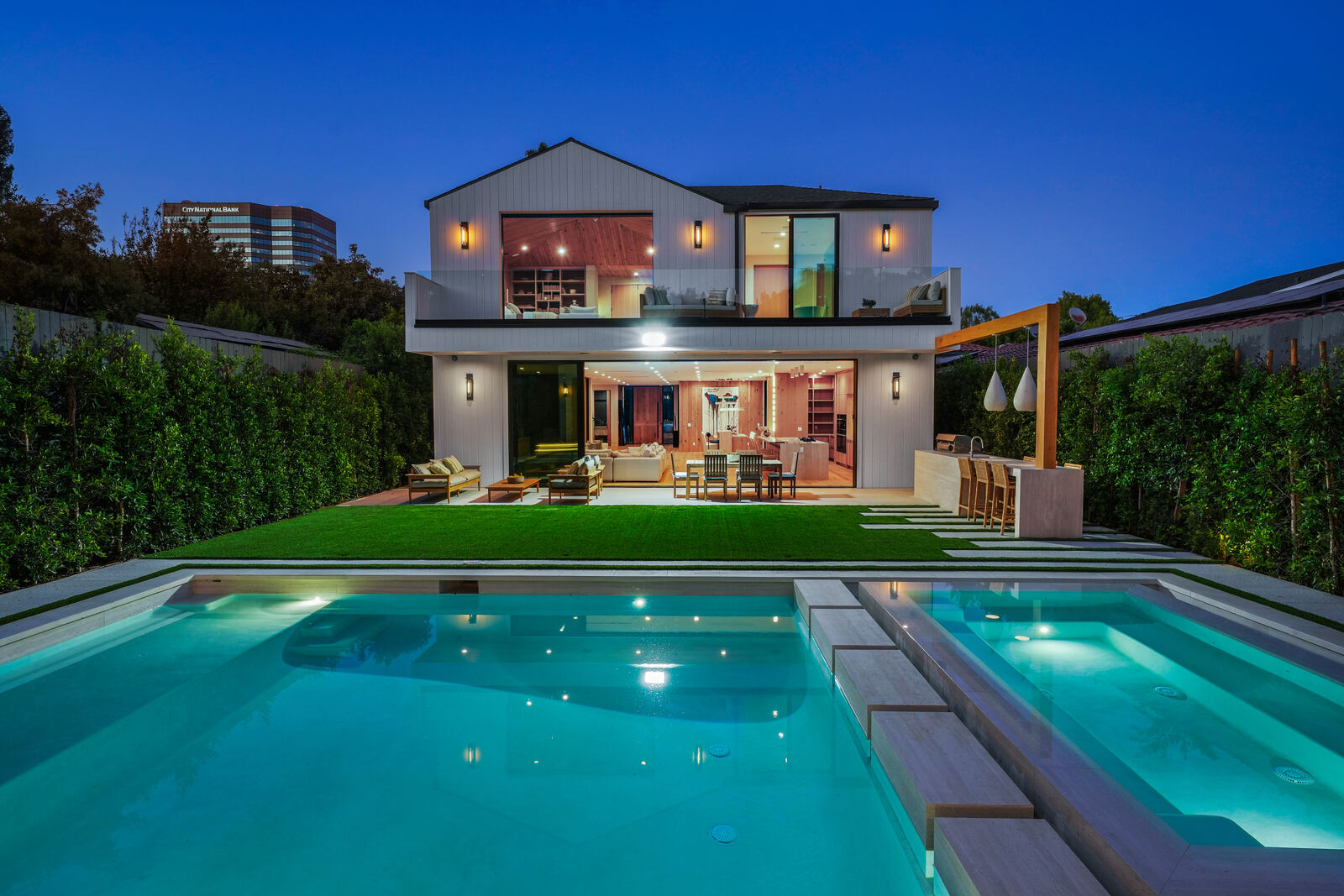 Los Angeles backyard pool and outdoor dining area at twilight