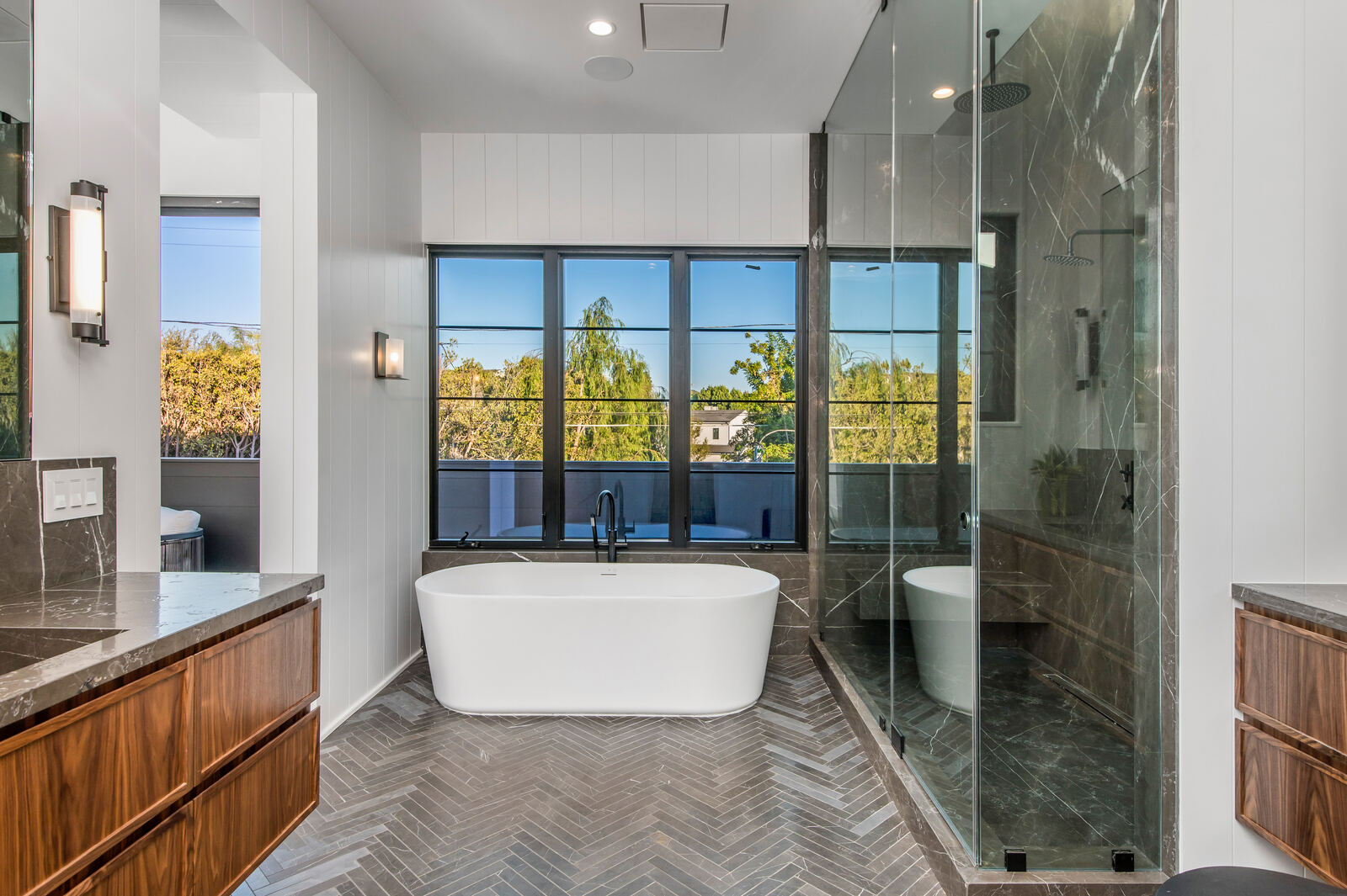 Van Nuys bathroom with freestanding tub and dark glass shower