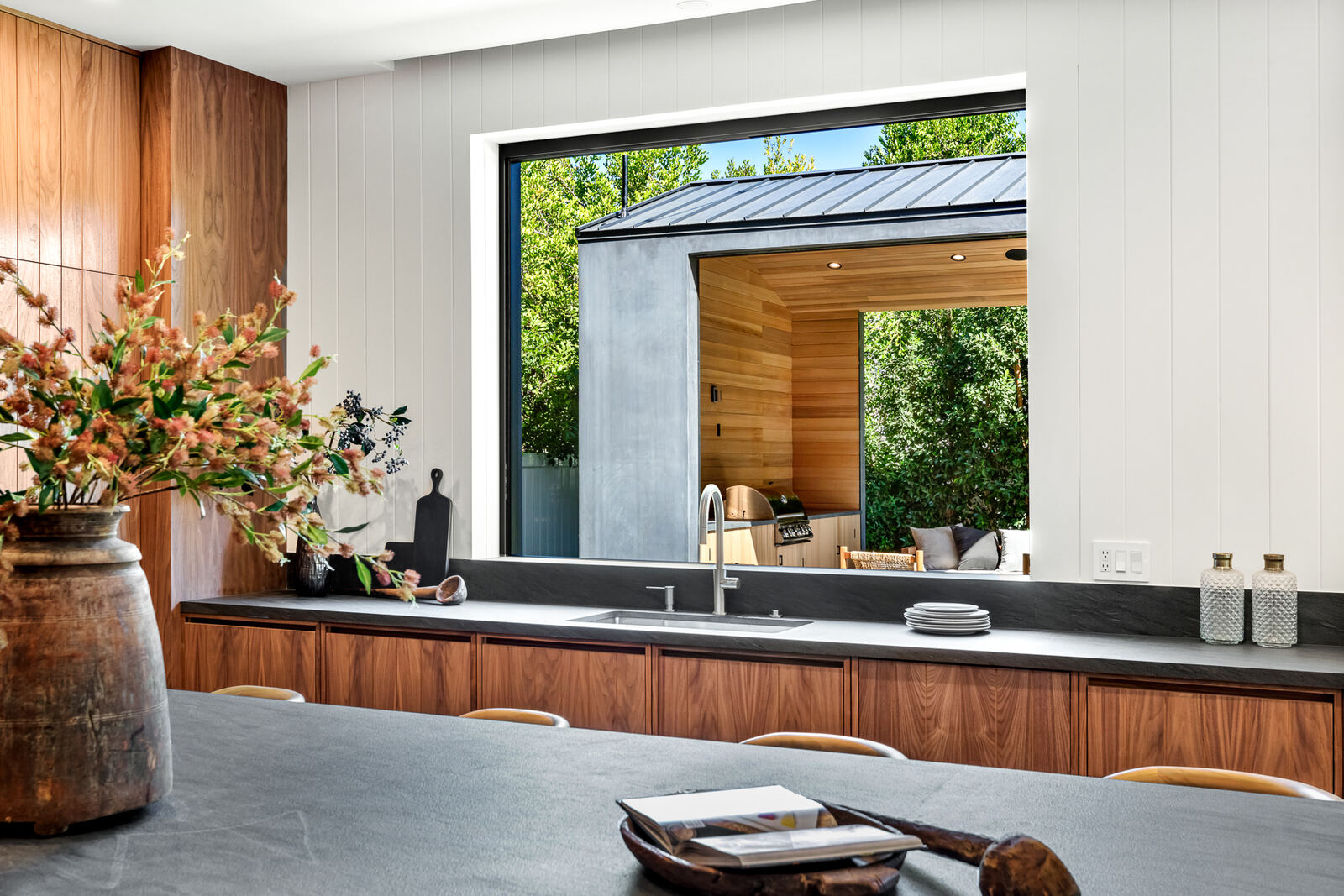 Los Angeles kitchen looking through a pass-through window to an outdoor pavilion