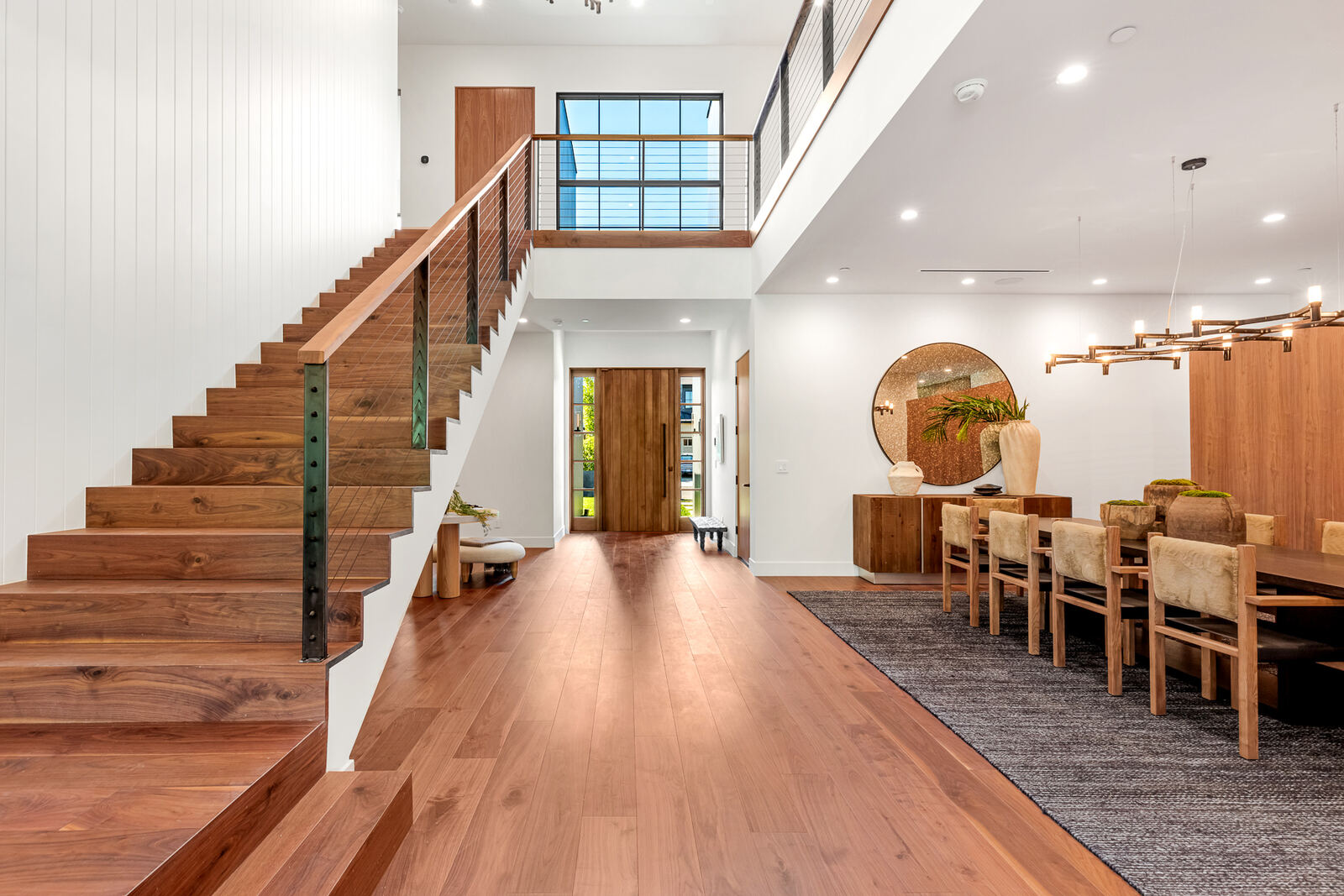 Two-story Los Angeles entry with wood staircase and adjacent dining area